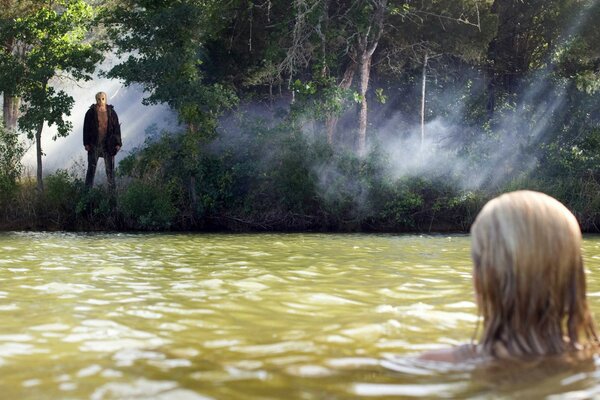 Bañando a una joven en un lago forestal
