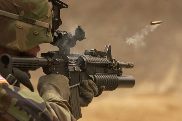 A soldier in camouflage firing a weapon