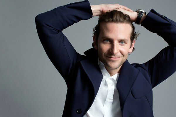 Aktor Bradley Cooper na szarym tle