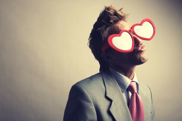 A brutal man in a suit and huge glasses in the form of hearts