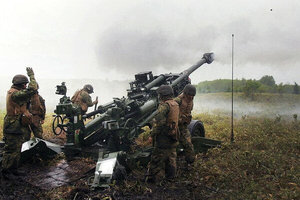 Howitzer-firing military at the river