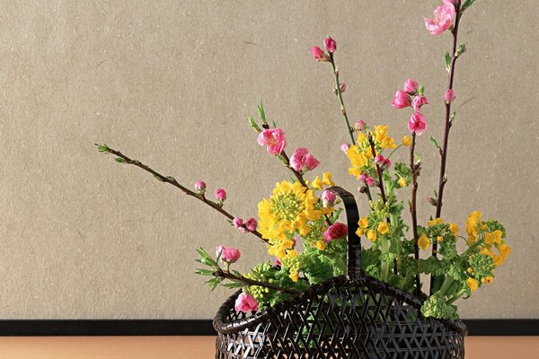 Ikebana japonesa de flores en una canasta negra
