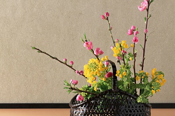 Ikebana giapponese di fiori in un cesto nero