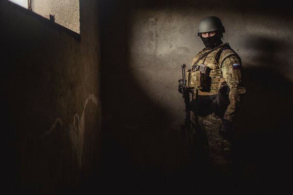 Un soldat des forces spéciales se tient près d un mur de béton