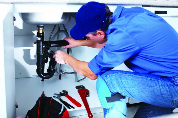 The master repairs the faucet in the kitchen