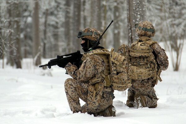 Soldiers with weapons in the winter forest