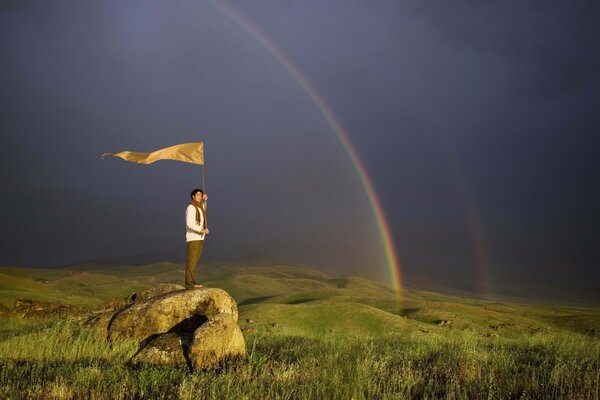 Homme avec drapeau sur pierre