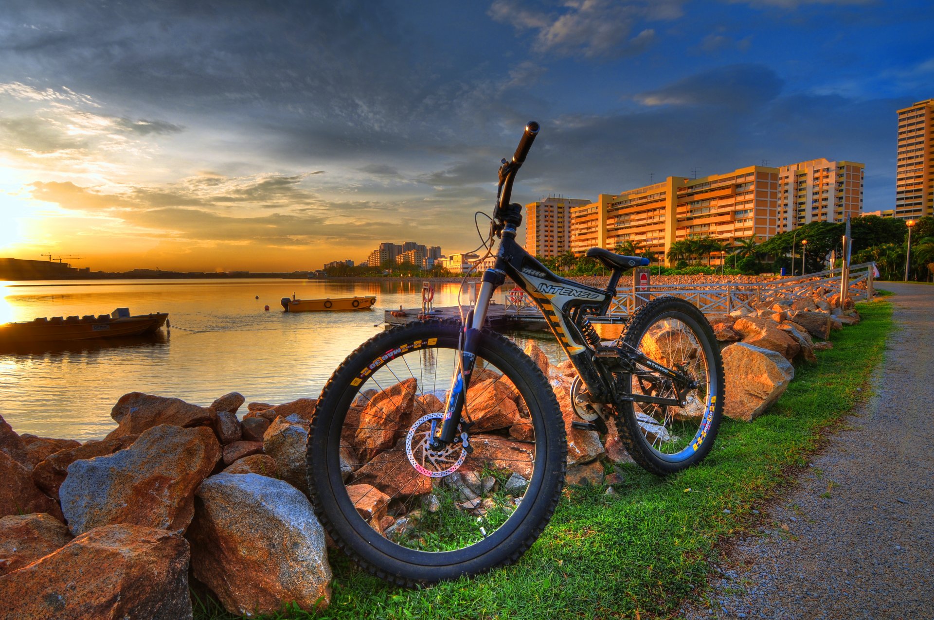 ciudad bicicleta piedras río barcos puesta de sol