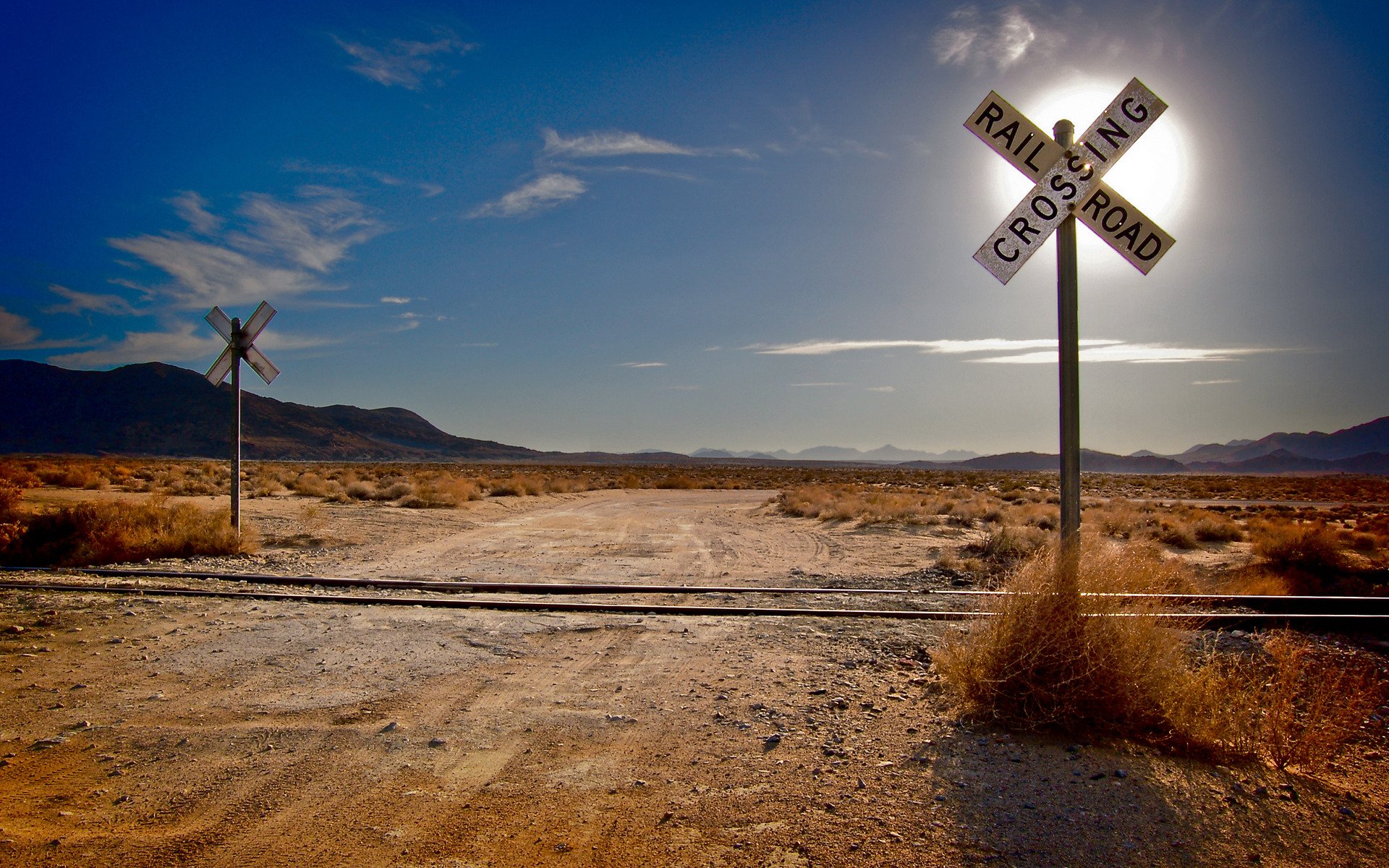 landschaften gras wüste wüsten eisenbahn eisenbahn schienen schwellen sonne berge wolken wolke straße straßen kreuzungen