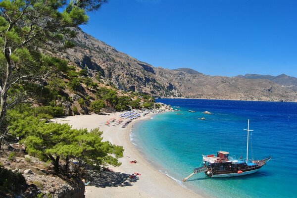 Griechischer Strand und Yacht vor der Küste