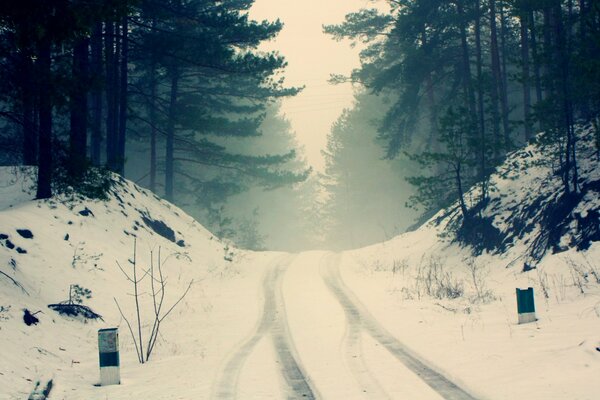 A snow-covered road in a foggy haze