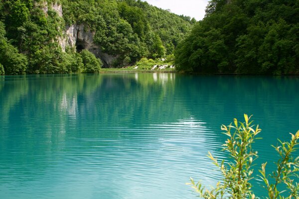 Blue lagoon on the background of high green rocks