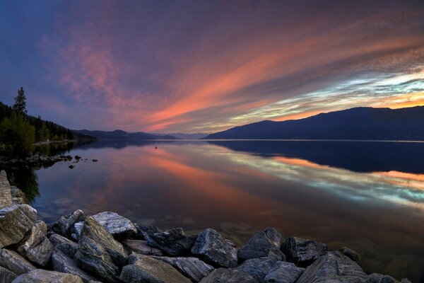 Roter Sonnenuntergang über einem See in den Bergen