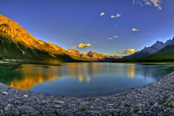 The shore of a mountain lake at sunset