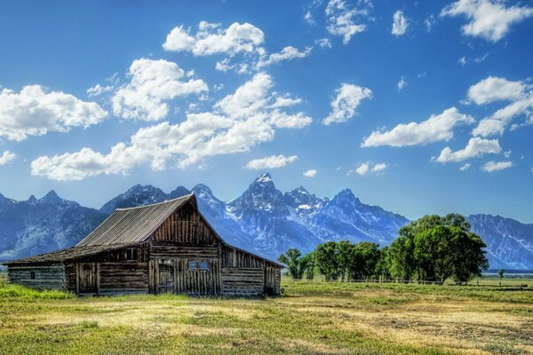 Holzhütte im Feld vor dem Hintergrund der Berge