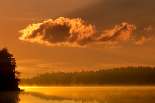 Orange sunset on the lake. Fog over the lake