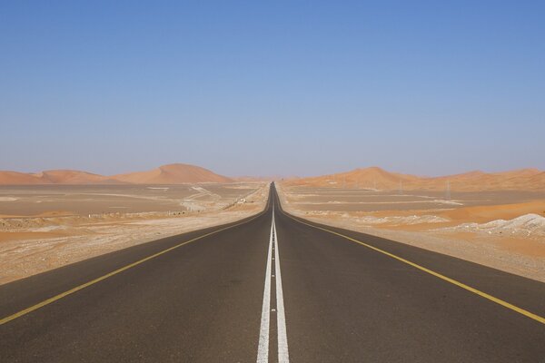 Pista nel deserto, in lontananza si vedono barkhans di sabbia