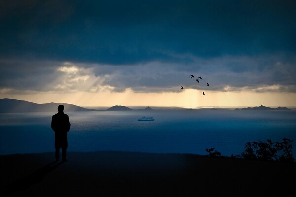 A man in the evening on the edge of a cliff