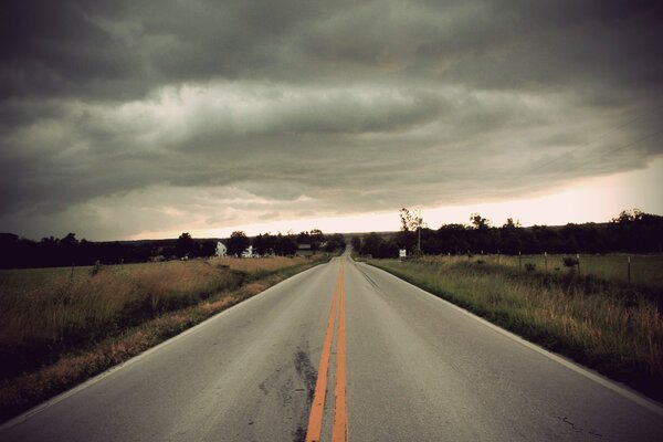 Dark clouds over the field and road