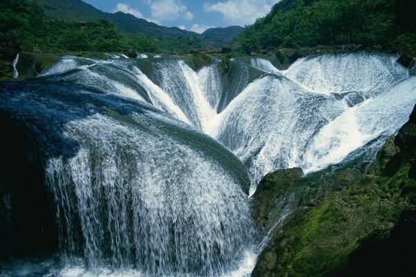 Paesaggio di cascata con pietre verdi