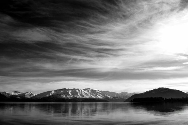 A gloomy landscape with a lake and mountains