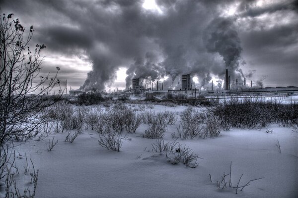 Industrial winter landscape with a view of smoke from factory chimneys