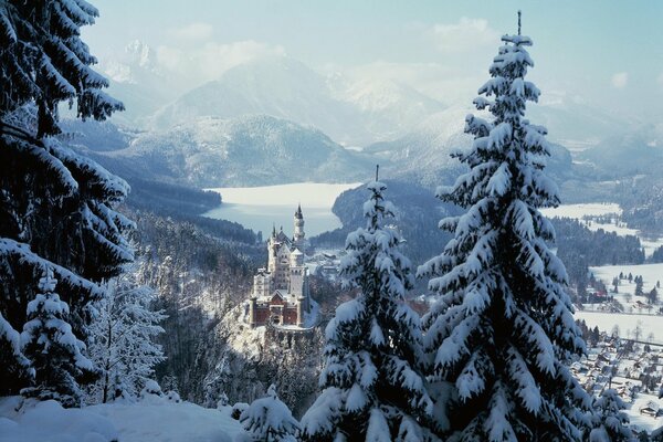 A castle among mountains and snow-covered pines