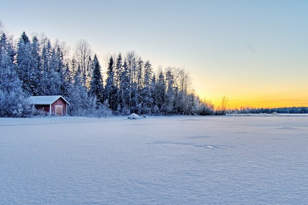 Sonnenuntergang am Ufer eines zugefrorenen Sees