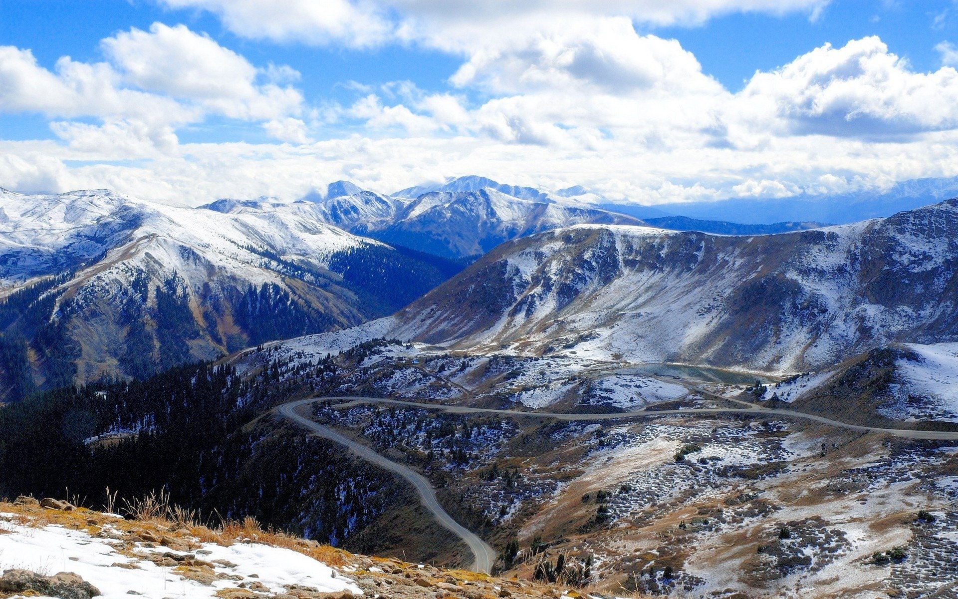 carretera de montaña rocas colinas hierba paisajes montañas nieve carreteras nubes