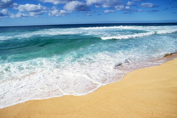 A beach with white sand and sea waves