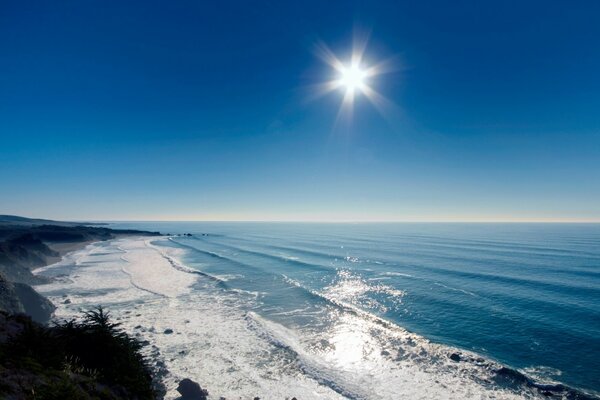 Los rayos del sol brillan en el océano, las rocas, la costa