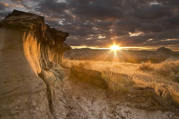 Tramonto tra le nuvole vicino a un campo roccioso