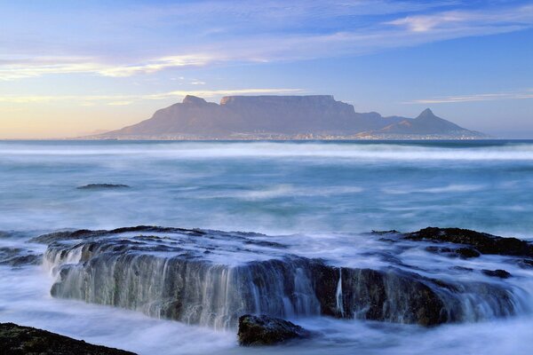 Landscape with ocean and waterfalls on the background of mountains