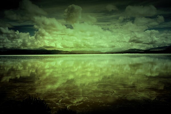 Nubes verdes se reflejan en el lago