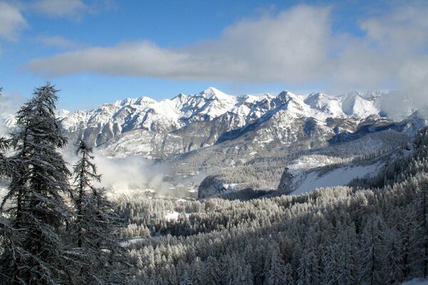 Clouds in the blue sky over snowy mountains