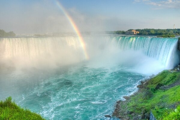 Regenbogen über einem Bergfall. Landschaft