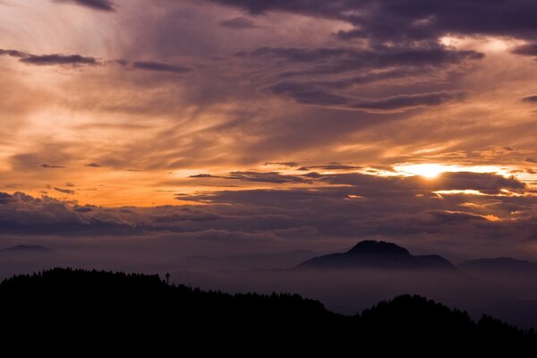 Beautiful sunset behind clouds and mountains