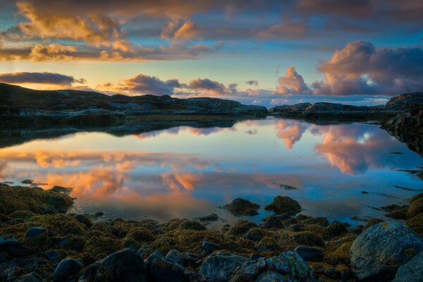 Am Ufer eines Sees in Norwegen. Reflexion des Sonnenuntergangs im Wasser