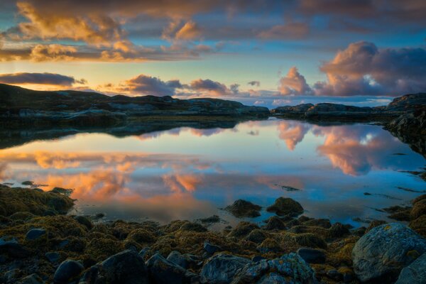 Nad jeziorem w Norwegii. Odbicie zachodu Słońca w wodzie