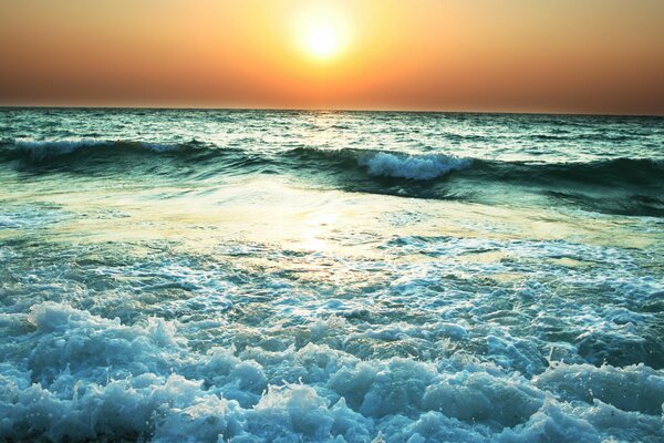 La puesta de sol vespertina se refleja en el mar furioso