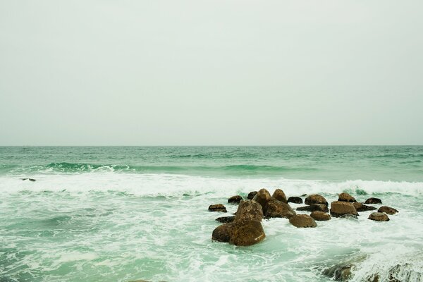 Les vagues qui se brisent sur les rochers apportent beaucoup d éclaboussures