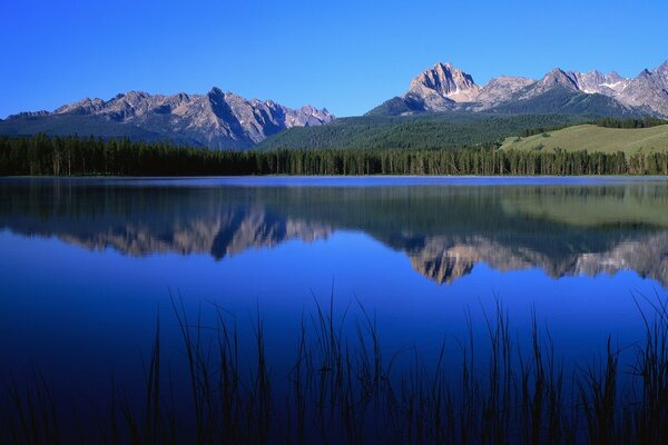 Ein blauer See, in dem sich die Berge widerspiegeln