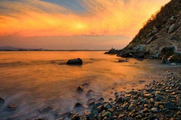 Amazing clouds by the sea and a stone cliff