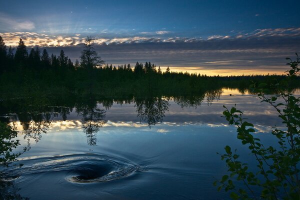 Jezioro odbija błękitne niebo i zachód słońca
