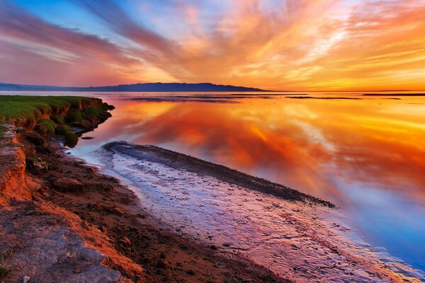 Mud bank under a colorful sky