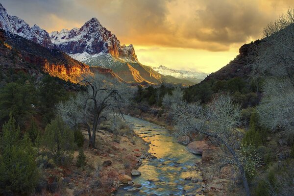 Río de montaña al atardecer. Una montaña en el horizonte