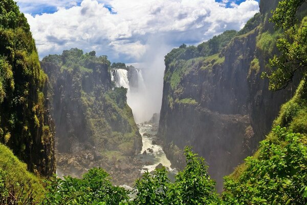 The landscape is green in the mountains, the sky is visible in the gorge between them