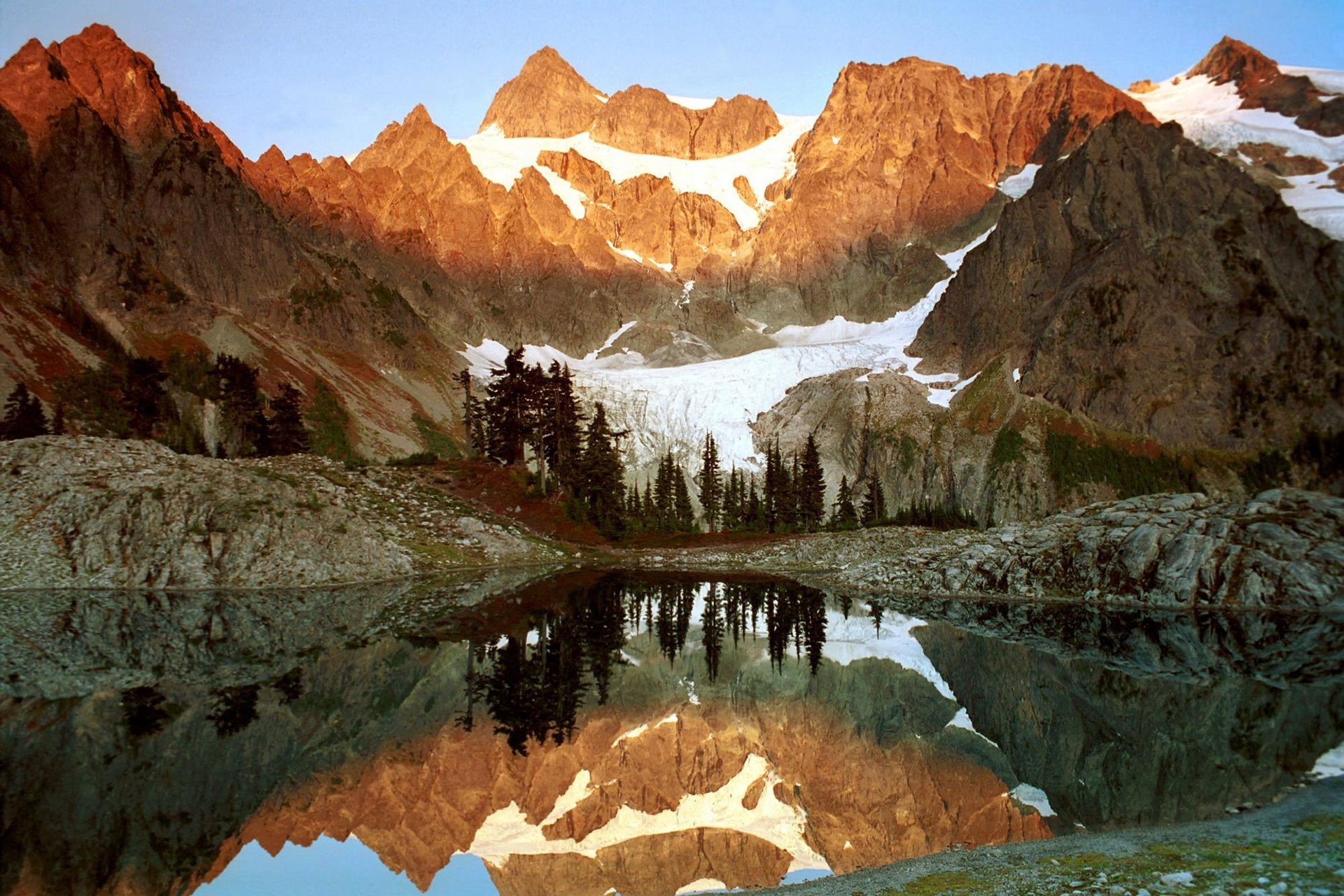 agua reflejos montañas hielo glaciar arboles pinos rocas
