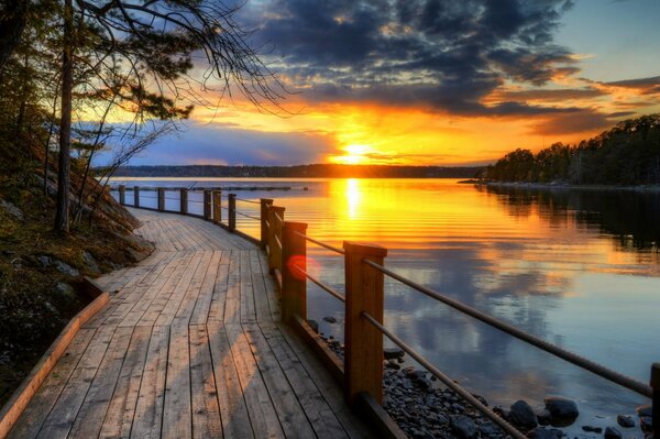 The bridge on the ocean beach fascinates with the view of the dawn