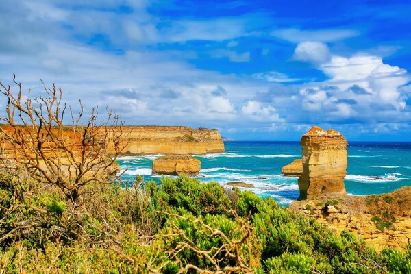 Mar azul, cielo y nubes. Rocas en el horizonte